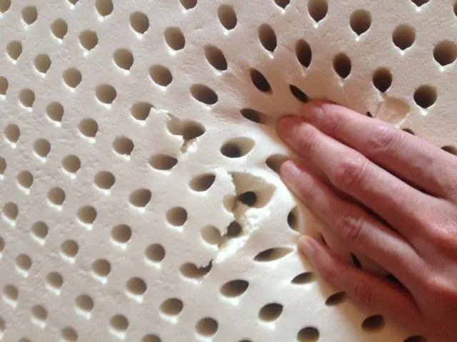 Natural latex mattress layer laid flat showing minor tears are invisible during use