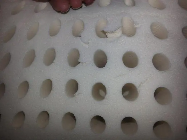 Small rips in natural latex mattress layer from baking pin removal, normal manufacturing variation