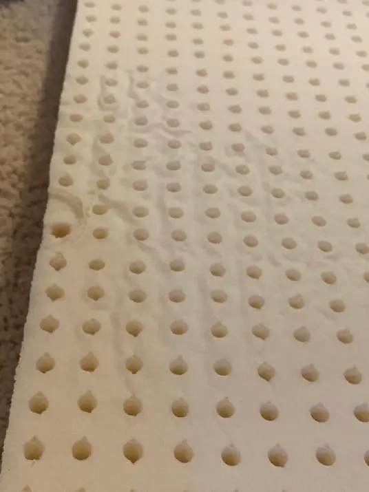 Surface texture inconsistencies on natural latex layer, undetectable when encased