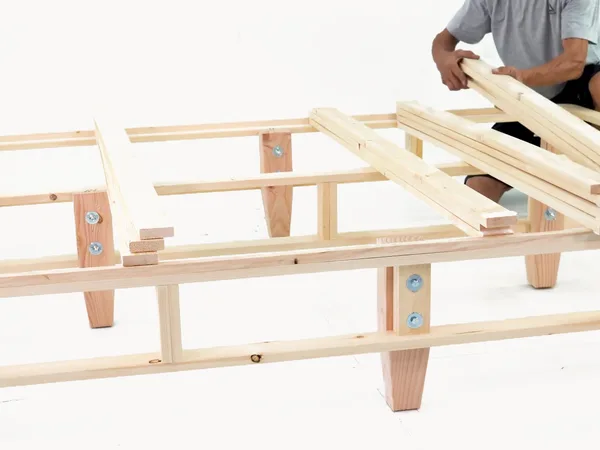 Heavy-duty foundation assembly step 20: Add the next slats over the leg positions.