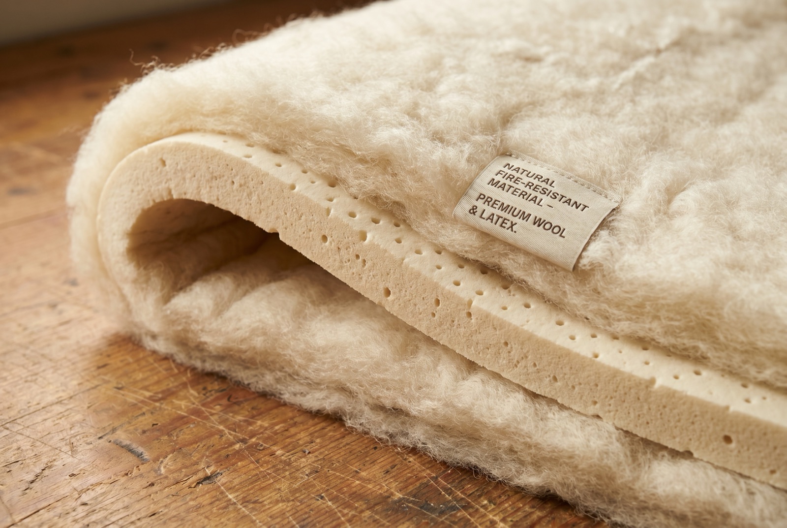 Natural wool batting wrapped around a layer of natural latex foam on a workbench