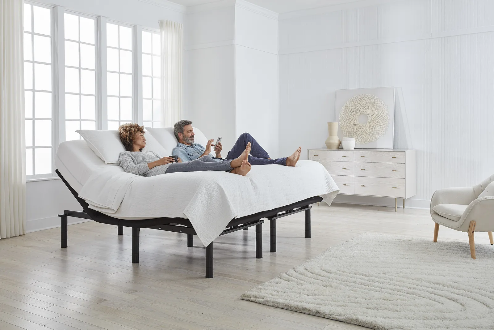 Couple relaxing on a split king Ergomotion adjustable bed with heads raised independently