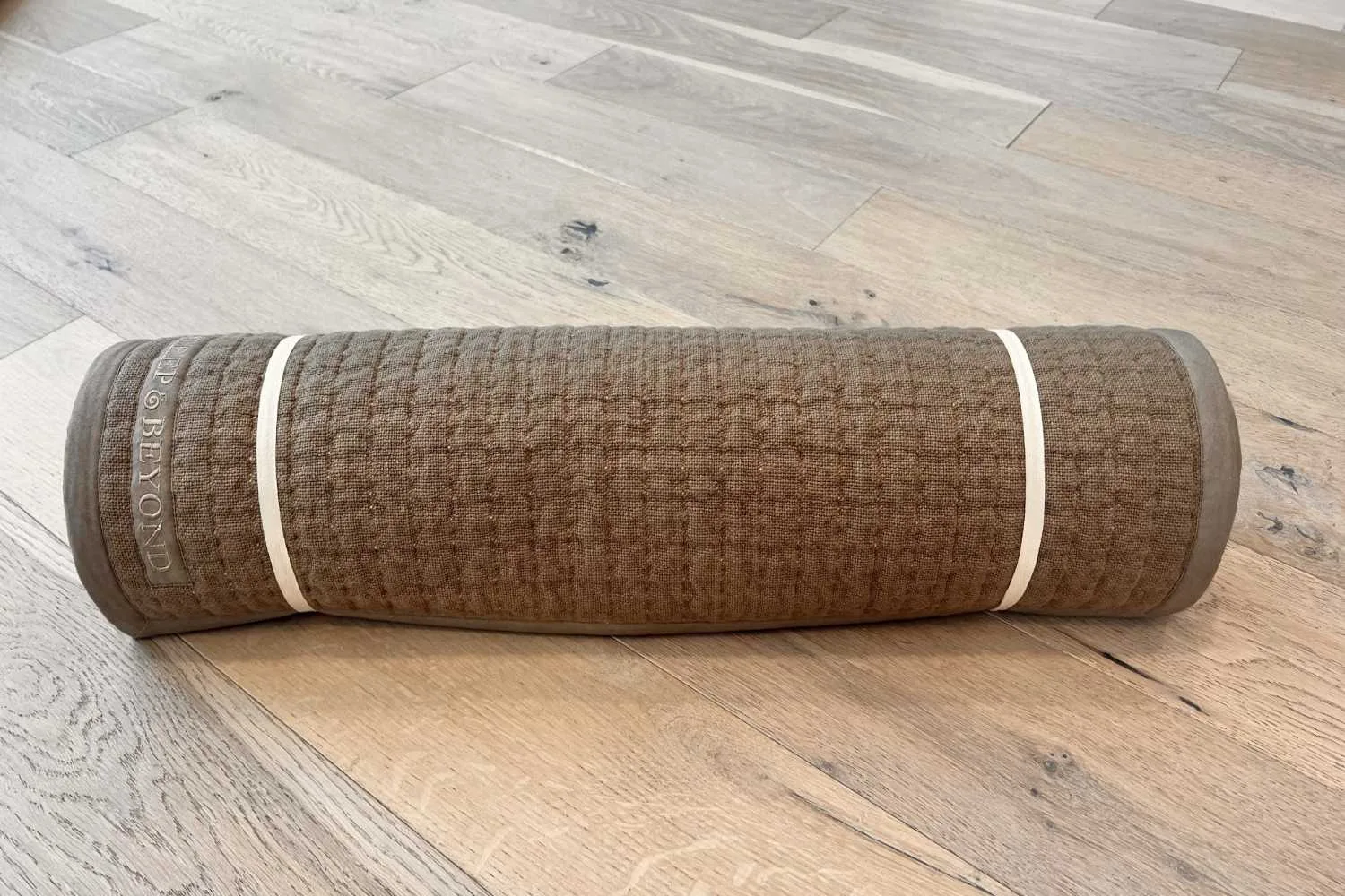 Natural non-slip yoga mat rolled in light brown color
