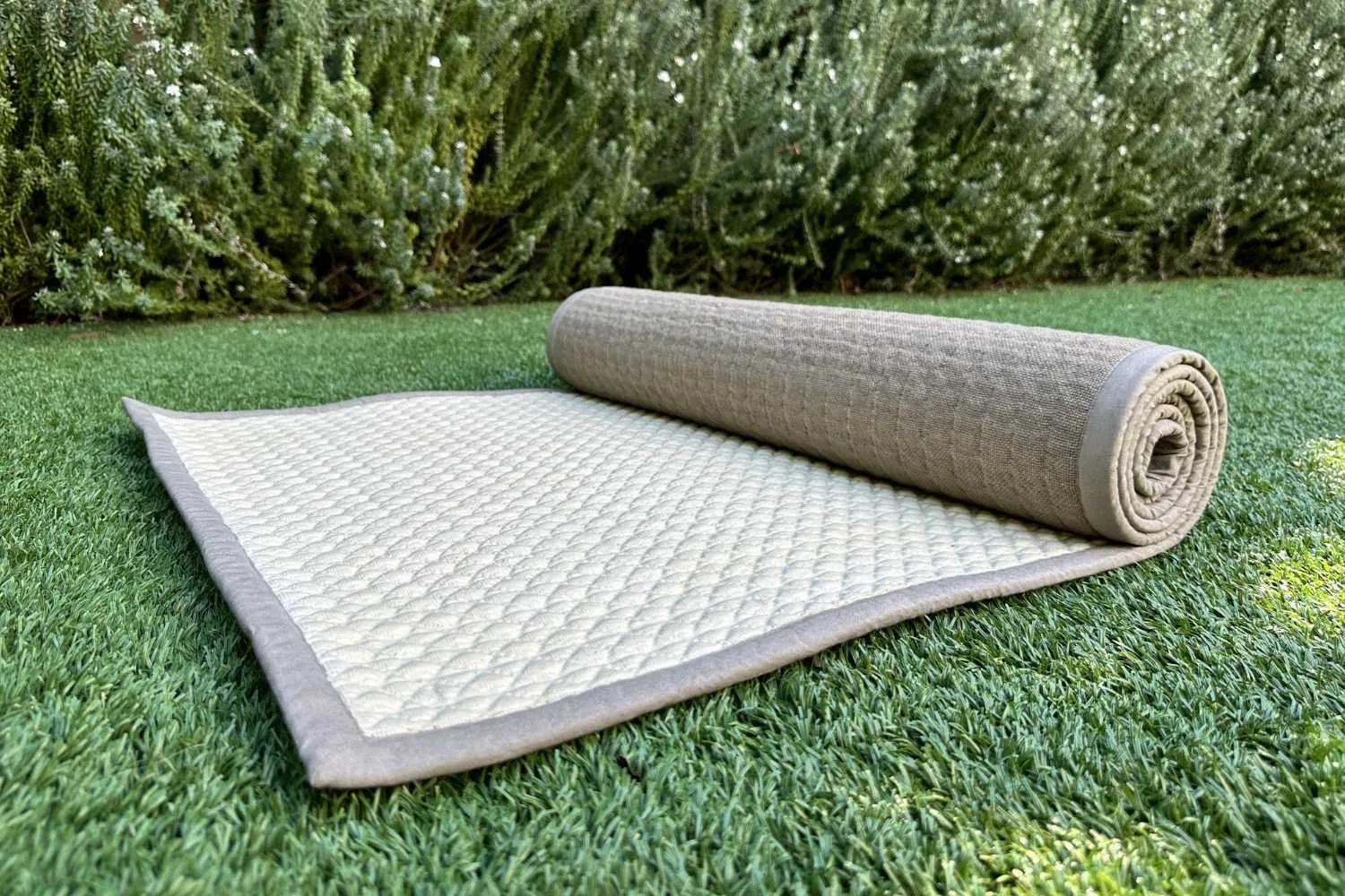 Natural non-slip yoga mat partially unrolled on grass